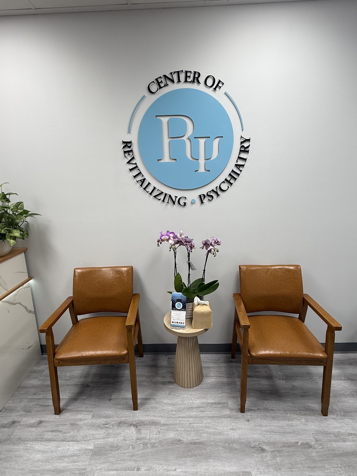 Waiting area with the logo wall and orchids